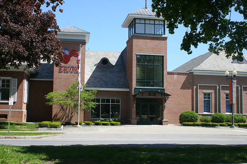 Street view of national racing hall of fame, a brick building with trees in front