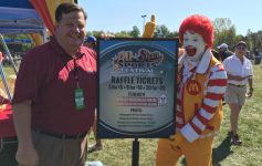 a man standing in front of a raffle ticket sign with Ronald McDonald