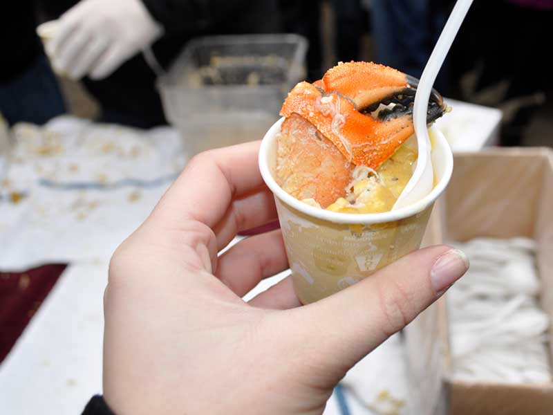 Chowder sample with crab claw garnish