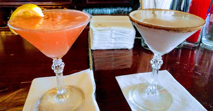 two martinis, one pink lemonade and one chocolate-y, on a bar