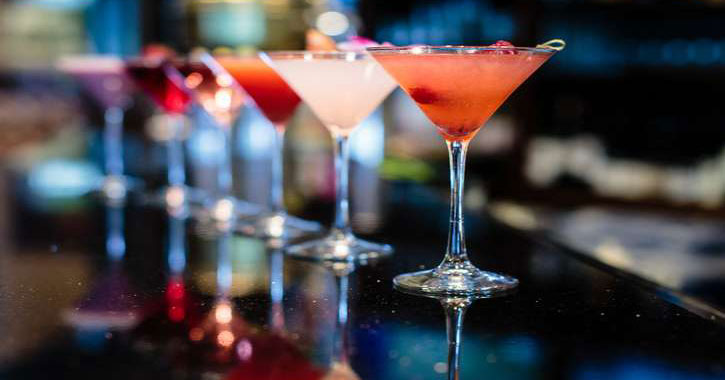 line up of colorful cocktails on the bar