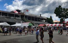 people walking near food booths at the track