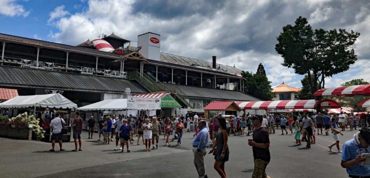 people walking near food booths at the track