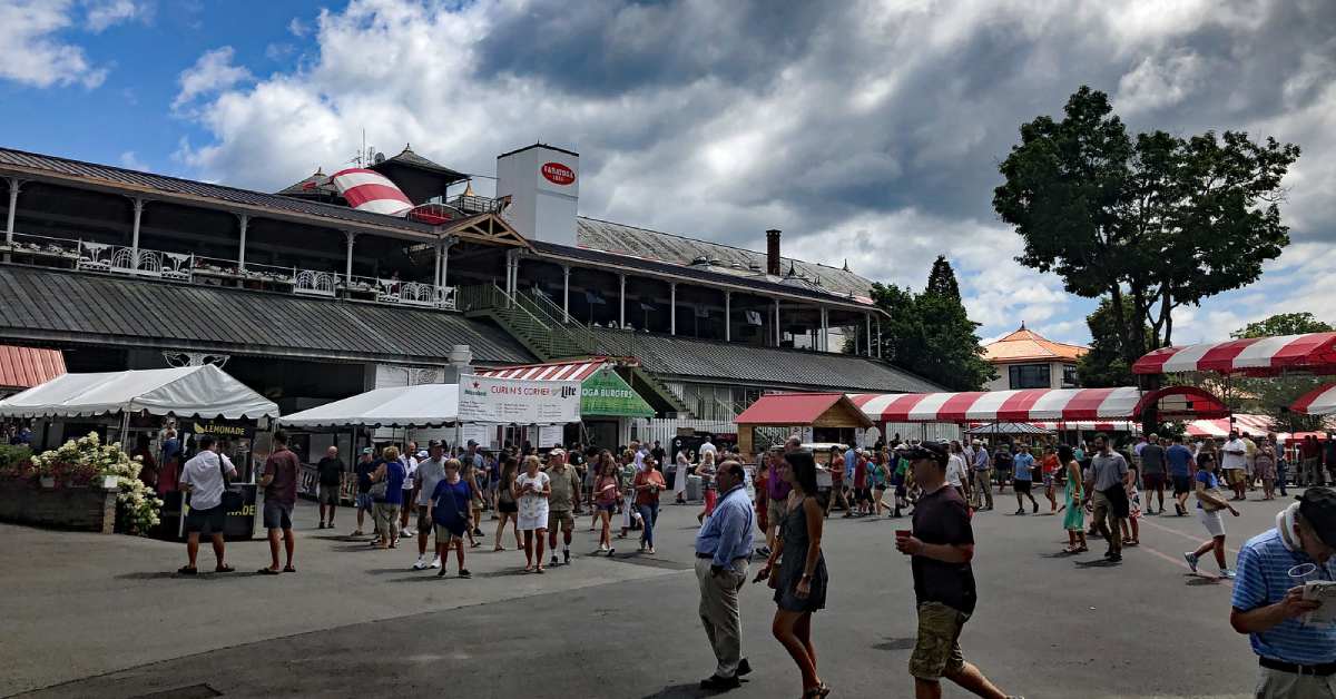 people walking near food booths at the track